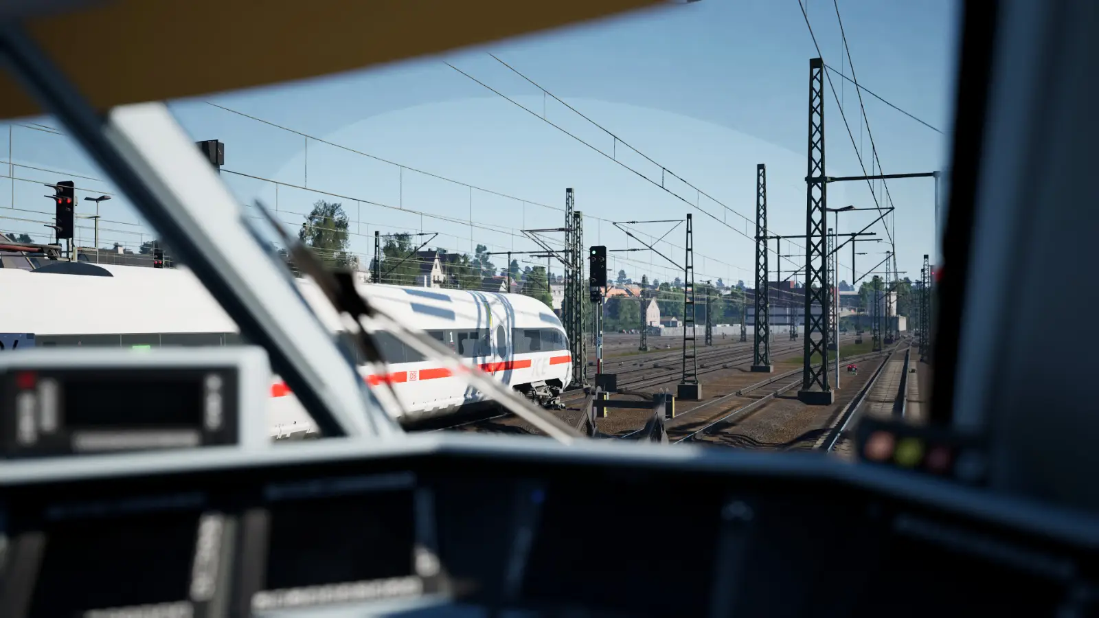 Seen through the driver's cab of another train, the ICE-T departs a station. It is predominately white, with a strip of red along the lower third of the train.