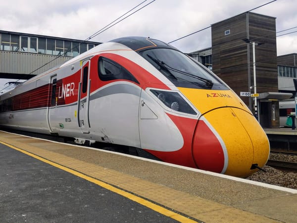 The train has a pointed front painted bright yellow. On the side of the train is a white and red livery.