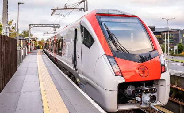 Front view of a modern Transport for Wales Class 756 train at a station platform, featuring sleek red and white branding.