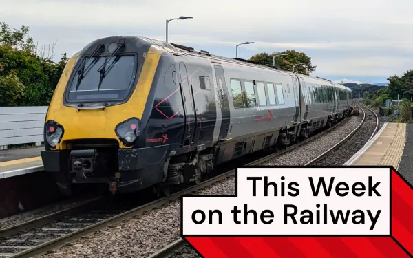 A CrossCountry train is stationary at Kirkcaldy station. It has a yellow front and purple livery with pink accents.