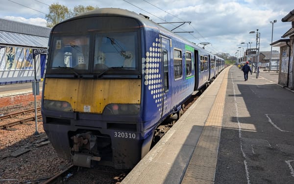 A weathered ScotRail Class 320 train sits at Lanark railway station.